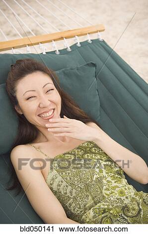 Asian woman laughing in hammock View Large Photo Image Stock Image - Asian woman laughing in hammock. Fotosearch