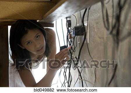 Asian woman looking at plugs under desk View Large Photo Image Stock Image - Asian woman looking at plugs under desk. Fotosearch