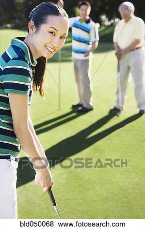 Stock Photo - Asian woman playing golf. Fotosearch