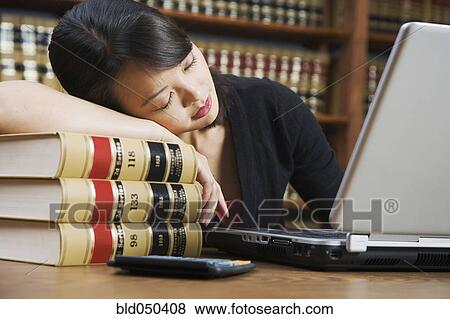 Asian woman sleeping on stack of library books View Large Photo Image Stock Photo - Asian woman sleeping on stack of library books. Fotosearch