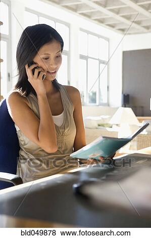 Stock Photo - Asian woman talking on cell phone. Fotosearch