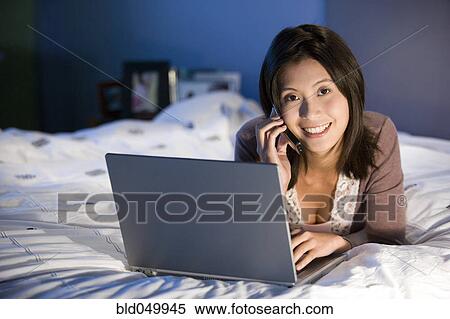 Stock Photography - Asian woman talking on cell phone. Fotosearch
