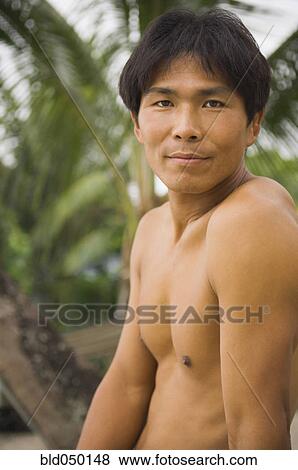 Close up of bare-chested Asian man View Large Photo Image Stock Photo - Close up of bare-chested Asian man. Fotosearch