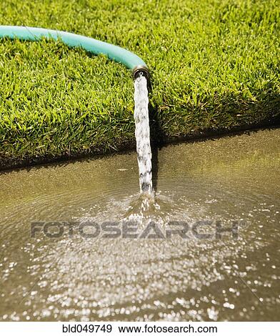 Close up of hose pouring onto sidewalk View Large Photo Image Stock Photo - Close up of hose pouring onto sidewalk. Fotosearch
