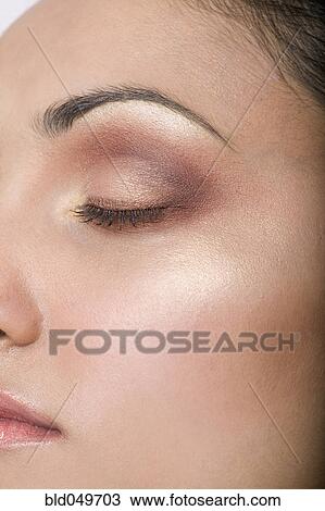 Stock Image - Close up of Indian woman with eye closed. Fotosearch