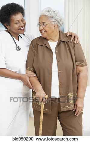 Doctor helping senior African American woman walk View Large Photo Image Stock Image - Doctor helping senior African American woman walk. Fotosearch