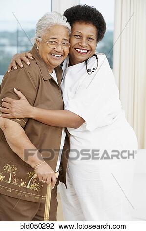 Doctor hugging senior African American woman View Large Photo Image Stock Image - Doctor hugging senior African American woman. Fotosearch