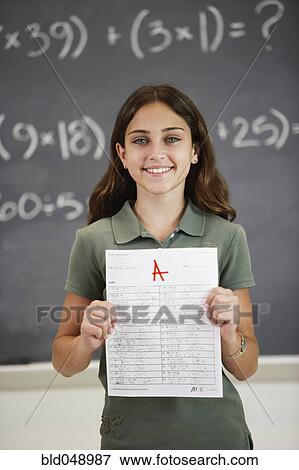 Girl holding up A paper View Large Photo Image Stock Photo - Girl holding up A paper. Fotosearch