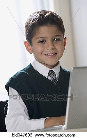 Hispanic boy typing on laptop View Large Photo Image Stock Image - Hispanic boy typing on laptop. Fotosearch