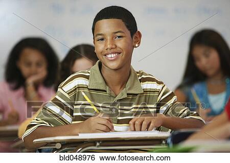 Hispanic boy writing at desk View Large Photo Image Stock Photograph - Hispanic boy writing at desk. Fotosearch