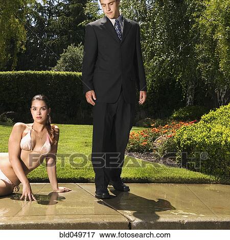 Hispanic businessman next to woman in bikini View Large Photo Image Stock Photo - Hispanic businessman next to woman in bikini. Fotosearch