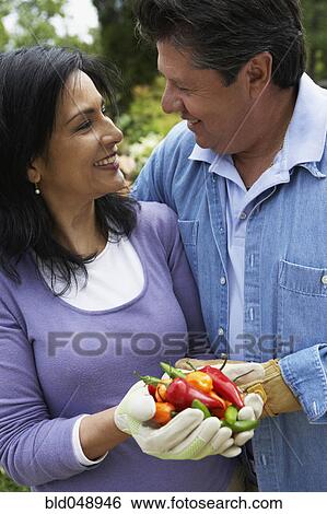 Stock Photograph - Hispanic couple holding peppers. Fotosearch