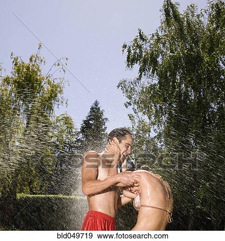 Hispanic couple standing in sprinkler View Large Photo Image Stock Photo - Hispanic couple standing in sprinkler. Fotosearch