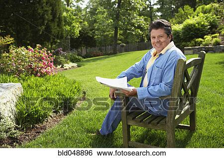 Hispanic man reading in backyard View Large Photo Image Stock Photograph - Hispanic man reading in backyard. Fotosearch