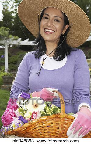 Hispanic woman holding basket of flowers View Large Photo Image Stock Image - Hispanic woman holding basket of flowers. Fotosearch