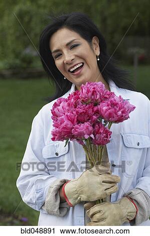 Hispanic woman holding flowers View Large Photo Image Stock Image - Hispanic woman holding flowers. Fotosearch