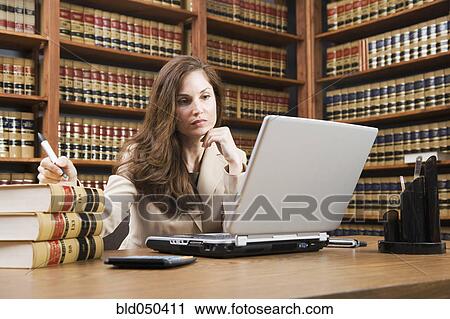 Stock Image - Hispanic woman looking at laptop. Fotosearch