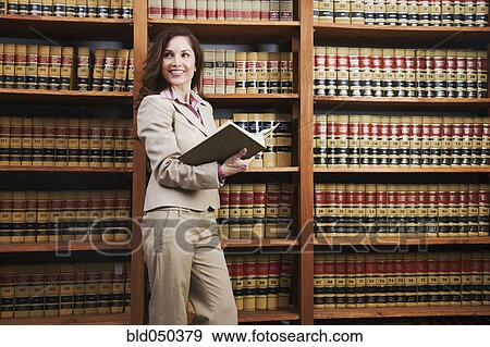 Stock Photo - Hispanic woman reading library reference book. Fotosearch