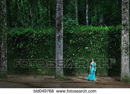 Stock Photo - Hispanic woman wearing evening gown in woods. Fotosearch