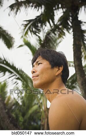 Low angle view of Asian man View Large Photo Image Stock Photo - Low angle view of Asian man. Fotosearch