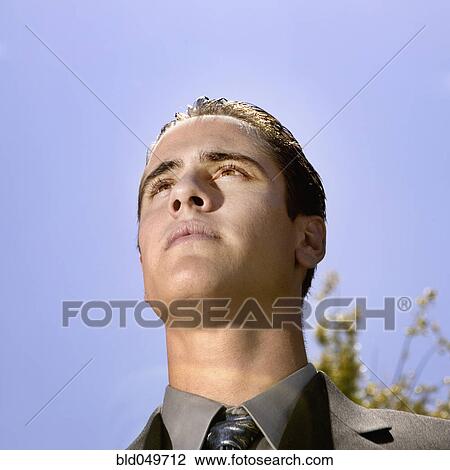 Stock Image - Low angle view of Hispanic businessman. Fotosearch