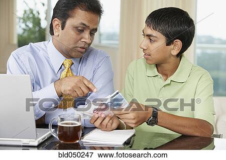 Middle Eastern father and son counting money View Large Photo Image Stock Photo - Middle Eastern father and son counting money. Fotosearch