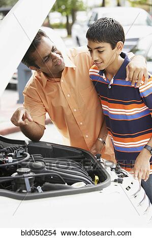 Middle Eastern father and son looking under car hood View Large Photo Image Picture - Middle Eastern father and son looking under car hood. Fotosearch