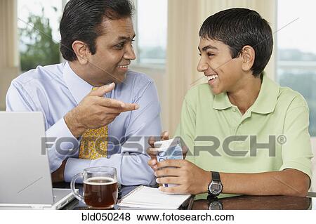 Stock Photo - Middle Eastern father and son smiling at each other. Fotosearch