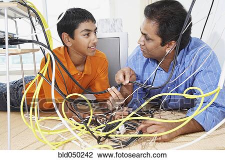 Middle Eastern father and son untangling wires View Large Photo Image Stock Image - Middle Eastern father and son untangling wires. Fotosearch