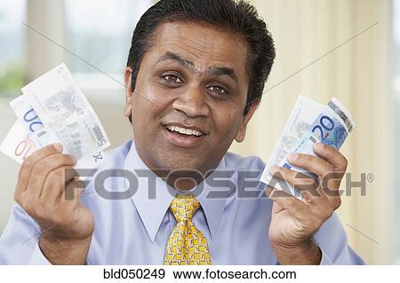 Middle Eastern man holding money View Large Photo Image Stock Photo - Middle Eastern man holding money. Fotosearch