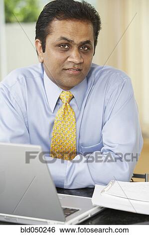 Middle Eastern man next to laptop View Large Photo Image Stock Photograph - Middle Eastern man next to laptop. Fotosearch