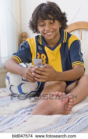 Mixed Race boy dialing cell phone View Large Photo Image Picture - Mixed Race boy dialing cell phone. Fotosearch