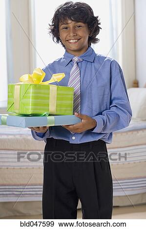 Mixed Race boy holding gifts View Large Photo Image Stock Photo - Mixed Race boy holding gifts. Fotosearch