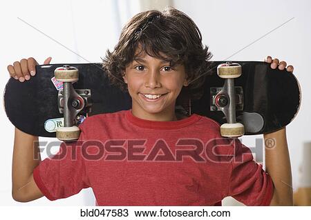 Mixed Race boy holding skateboard View Large Photo Image Stock Image - Mixed Race boy holding skateboard. Fotosearch