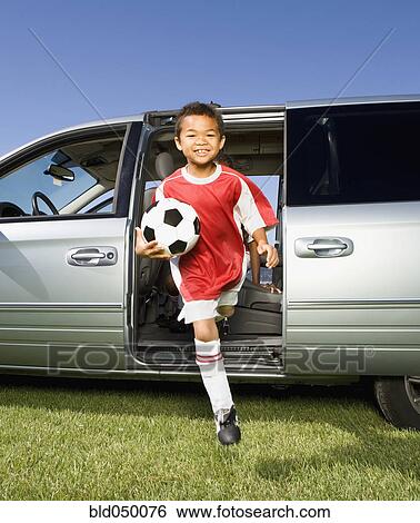Stock Photograph - Mixed Race boy holding soccer ball. Fotosearch