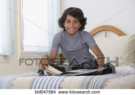 Mixed Race boy reading on bed View Large Photo Image Picture - Mixed Race boy reading on bed. Fotosearch
