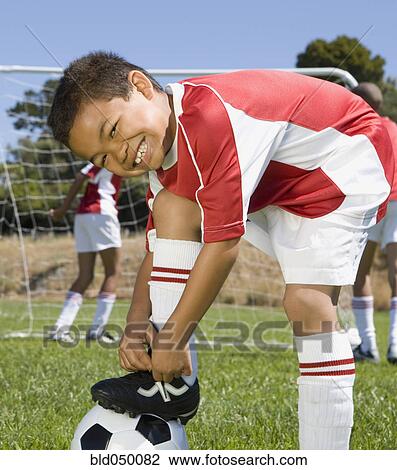 Mixed Race boy tying soccer shoe View Large Photo Image Stock Image - Mixed Race boy tying soccer shoe. Fotosearch