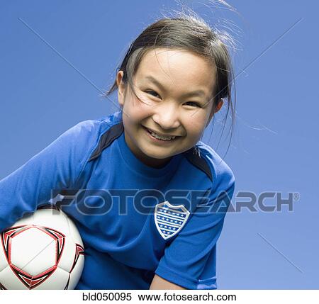 Stock Photography - Mixed Race girl holding soccer ball. Fotosearch