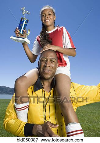 Mixed Race girl on soccer coach’s shoulders View Large Photo Image Stock Photo - Mixed Race girl on soccer coach’s shoulders. Fotosearch