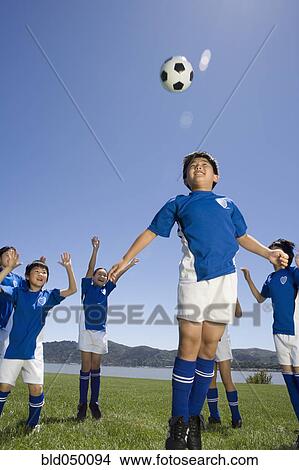 Picture - Multi-ethnic children playing soccer. Fotosearch