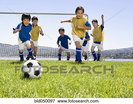 Multi-ethnic children playing soccer View Large Photo Image Stock Photo - Multi-ethnic children playing soccer. Fotosearch