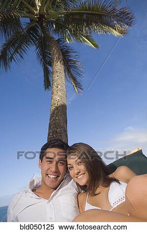 Multi-ethnic couple laying in hammock View Large Photo Image Stock Photography - Multi-ethnic couple laying in hammock. Fotosearch