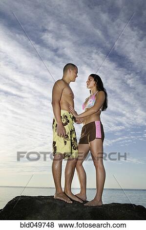 Stock Photo - Multi-ethnic couple smiling at each other. Fotosearch