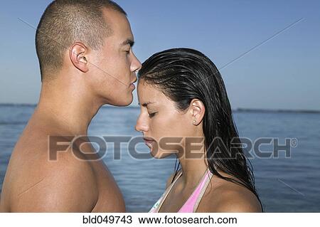 Stock Image - Multi-ethnic couple with eyes closed. Fotosearch