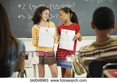 Multi-ethnic girls holding papers in front of class View Large Photo Image Stock Image - Multi-ethnic girls holding papers in front of class. Fotosearch