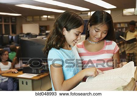 Multi-ethnic girls reading library dictionary View Large Photo Image Stock Image - Multi-ethnic girls reading library dictionary. Fotosearch