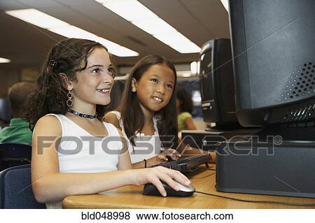 Multi-ethnic girls using school computer View Large Photo Image Stock Photo - Multi-ethnic girls using school computer. Fotosearch