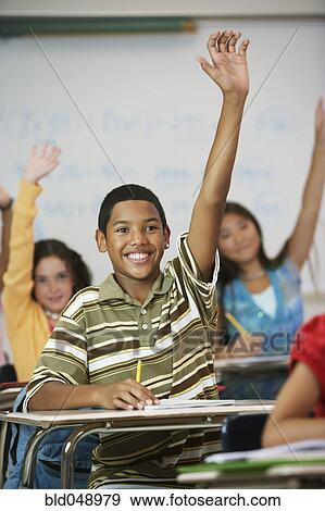 Multi-ethnic students raising hands in class View Large Photo Image Stock Photo - Multi-ethnic students raising hands in class. Fotosearch