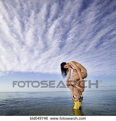 Pacific Islander woman sitting on boyfriend’s shoulders View Large Photo Image Stock Photograph - Pacific Islander woman sitting on boyfriend’s shoulders. Fotosearch
