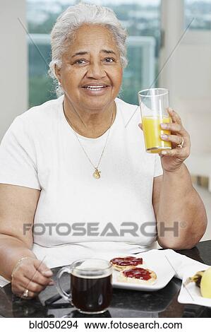Senior African American woman eating breakfast View Large Photo Image Picture - Senior African American woman eating breakfast. Fotosearch